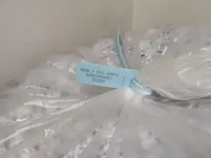 Colour-coded plastic security seal securing a recycling bin filled with shredded confidential paper waste